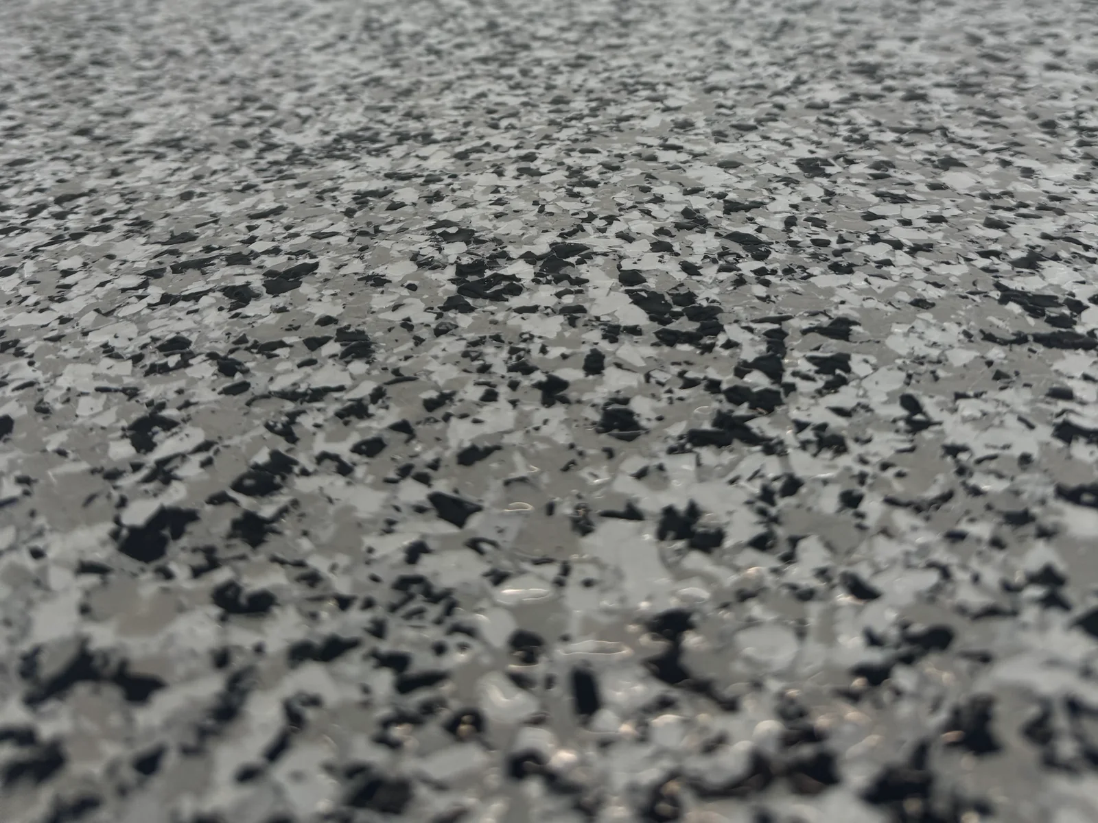 Close-up of a grey black and white epoxy flake garage floor in Brisbane