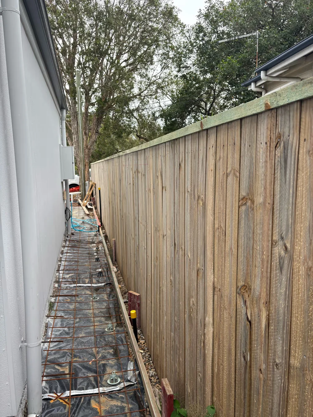 Timber boundary fence beside adjoining external construction works